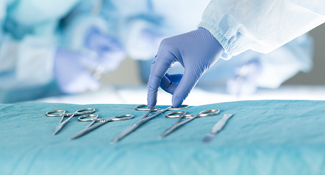 Manos con guantes agarrando pinzas para cirug�a